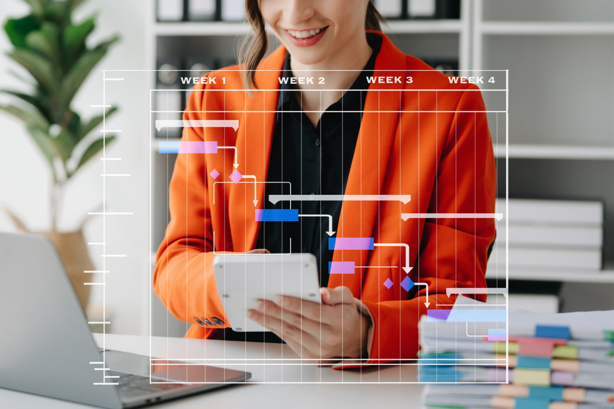 woman in bright orange blazer behind a gantt chart